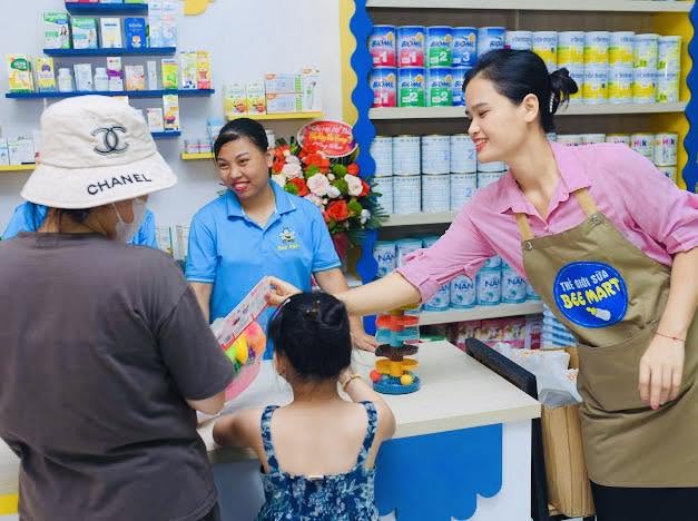 Nhân viên bán hàng tại quầy kệ trưng bày sữa bột Bee Mart Hạ Hòa
