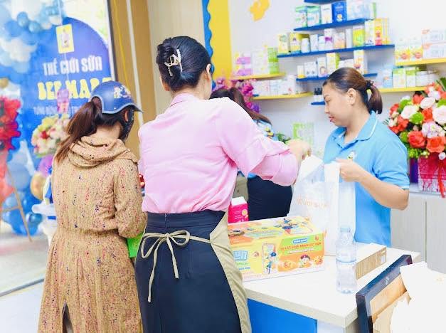 Khách hàng mua sắm và thanh toán sữa bỉm tại quầy thu ngân Bee Mart Hạ Hòa